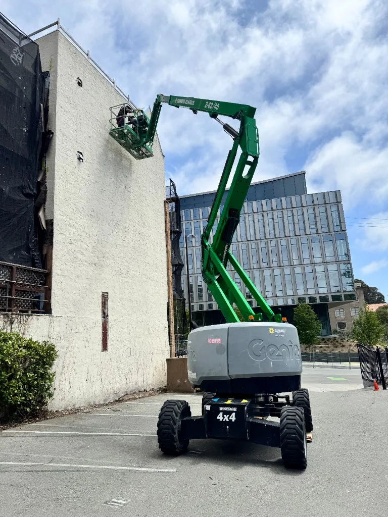 3rdGen technician in a boom lift working on exterior mechanical scope at a commercial building