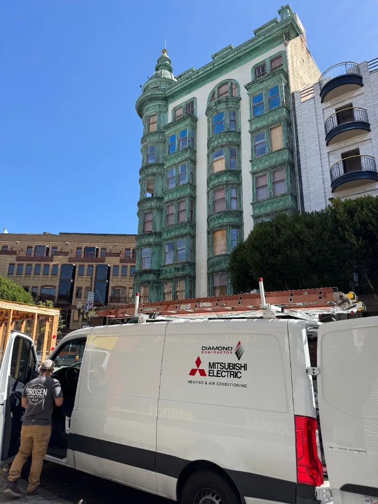Crew and equipment staged for early-morning HVAC replacement work on an occupied commercial street in San Francisco.